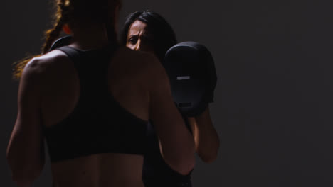 Nahaufnahme-Einer-Studioaufnahme-Von-Zwei-Reifen-Frauen-In-Fitnesskleidung,-Die-Gemeinsam-Boxen-Und-Sparring-Trainieren-3